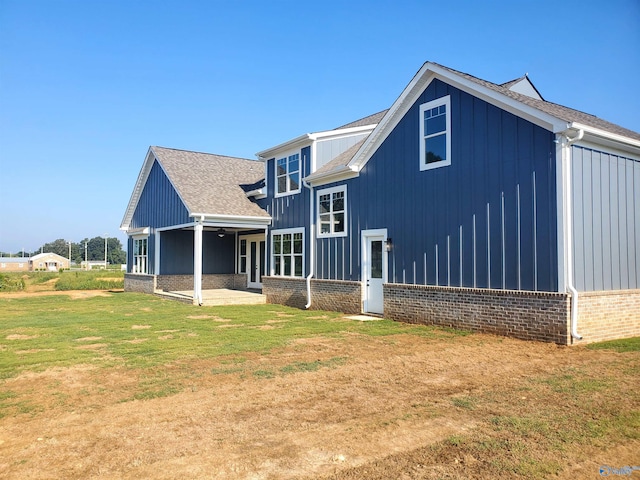 rear view of property featuring a lawn