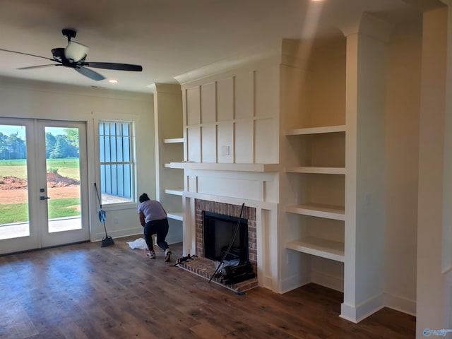 unfurnished living room featuring a fireplace, ceiling fan, french doors, and dark wood-type flooring