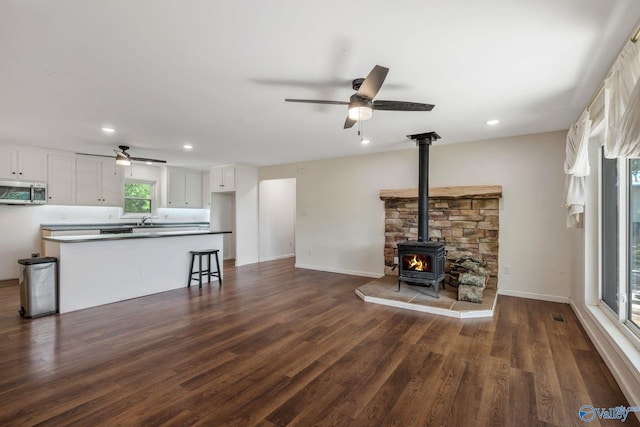 3621 Al Highway 36, Moulton, AL 35650 - unfurnished living room with a ceiling fan, a wood stove, dark wood finished floors, recessed lighting, and a sink