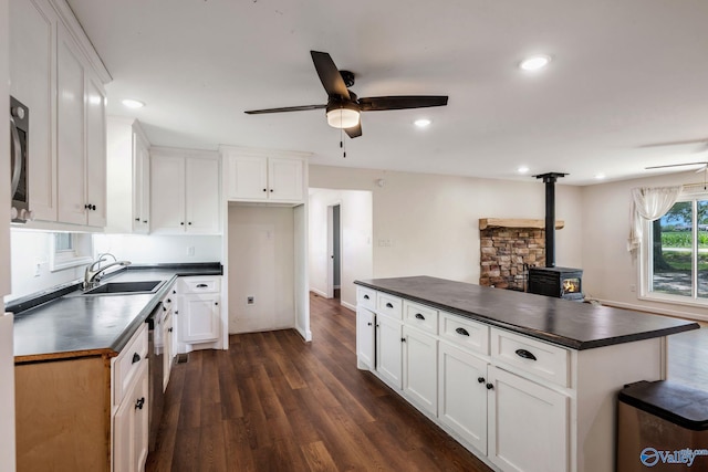 3621 Al Highway 36, Moulton, AL 35650 - kitchen with dark countertops, a ceiling fan, a sink, a wood stove, and recessed lighting