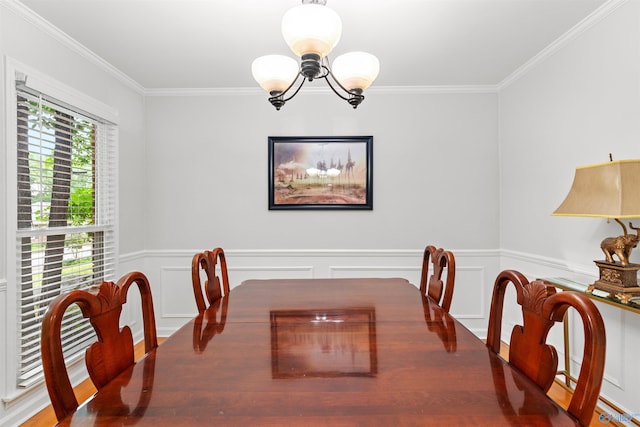 dining space with hardwood / wood-style floors, crown molding, and a notable chandelier