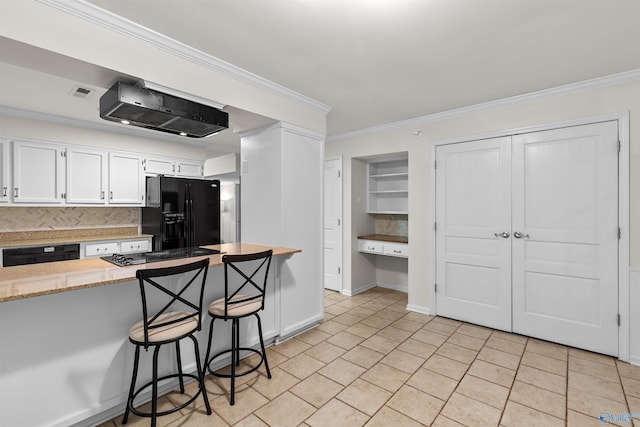 kitchen featuring black appliances, backsplash, white cabinets, ornamental molding, and a breakfast bar