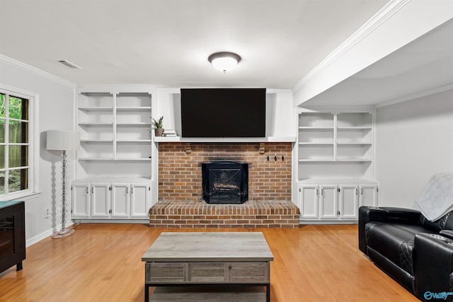 living room featuring a fireplace, ornamental molding, and light wood-type flooring