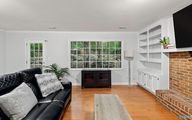 living room featuring a wealth of natural light, crown molding, light hardwood / wood-style flooring, and a fireplace