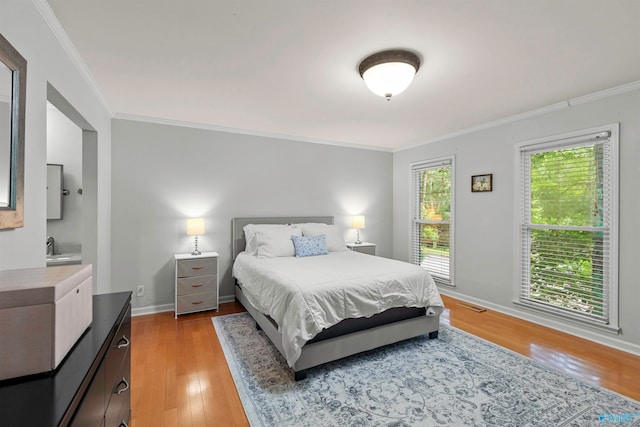 bedroom with ornamental molding and light wood-type flooring