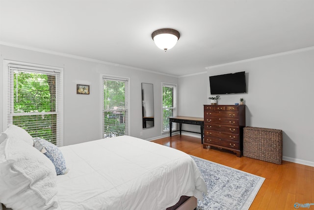 bedroom with crown molding and hardwood / wood-style flooring