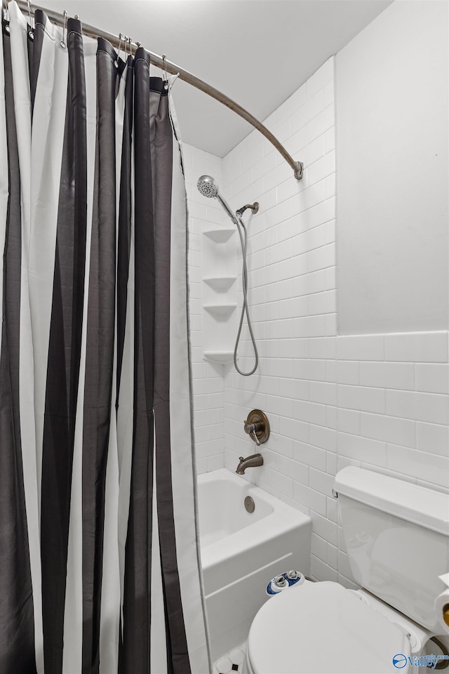 bathroom featuring toilet, shower / bath combo with shower curtain, and tile walls