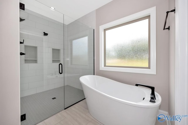 bathroom featuring separate shower and tub