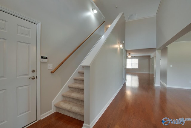 stairs with hardwood / wood-style floors and ornamental molding