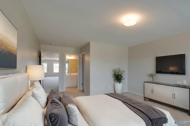 bedroom featuring connected bathroom and light colored carpet