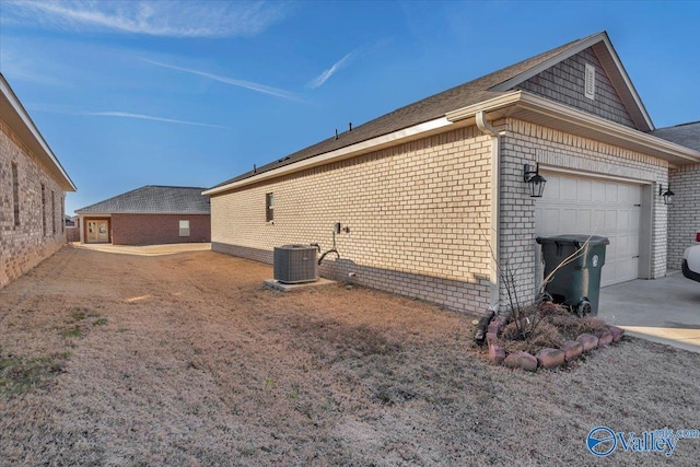 view of side of property with a garage and central air condition unit