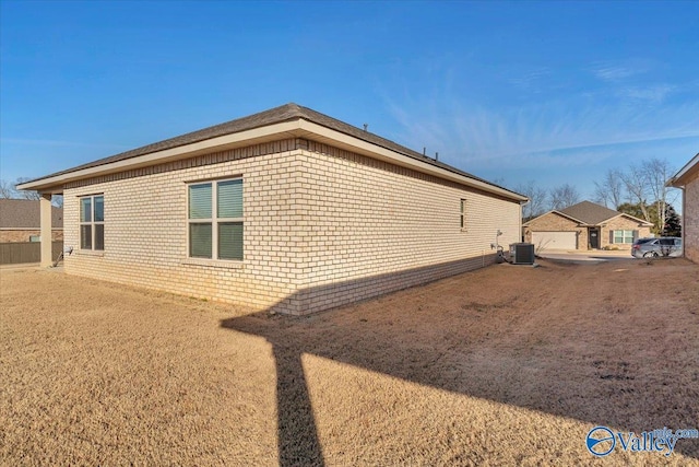 view of side of property with a garage and central air condition unit