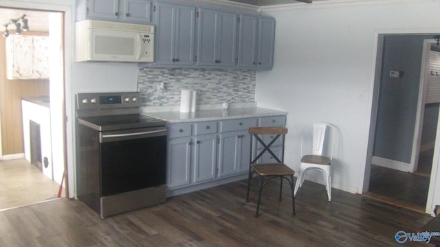 kitchen featuring electric range, dark hardwood / wood-style flooring, ornamental molding, and tasteful backsplash