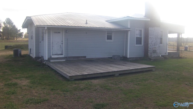 back of house featuring cooling unit, a deck, and a yard