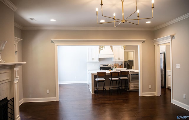 kitchen featuring a kitchen bar, custom exhaust hood, stainless steel appliances, a fireplace, and white cabinets