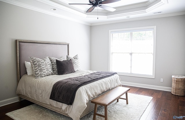 bedroom with a raised ceiling, ornamental molding, dark hardwood / wood-style floors, and multiple windows