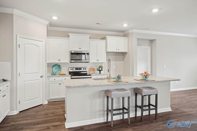 kitchen featuring stainless steel appliances, light stone countertops, an island with sink, and white cabinets