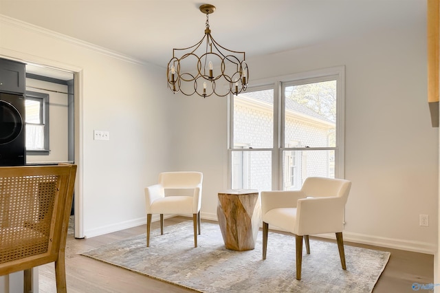 sitting room with an inviting chandelier, hardwood / wood-style floors, and crown molding