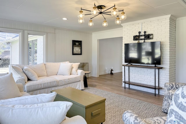 living room featuring crown molding, light hardwood / wood-style flooring, and a notable chandelier
