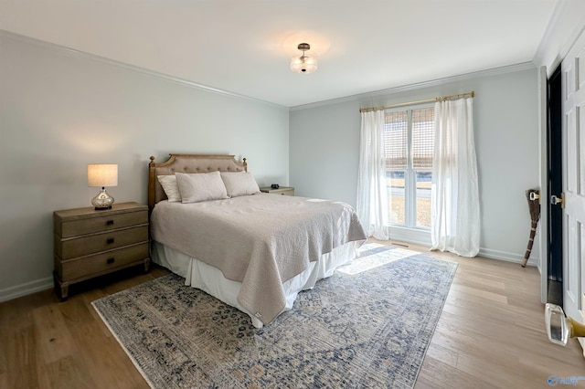 bedroom with ornamental molding and light hardwood / wood-style flooring
