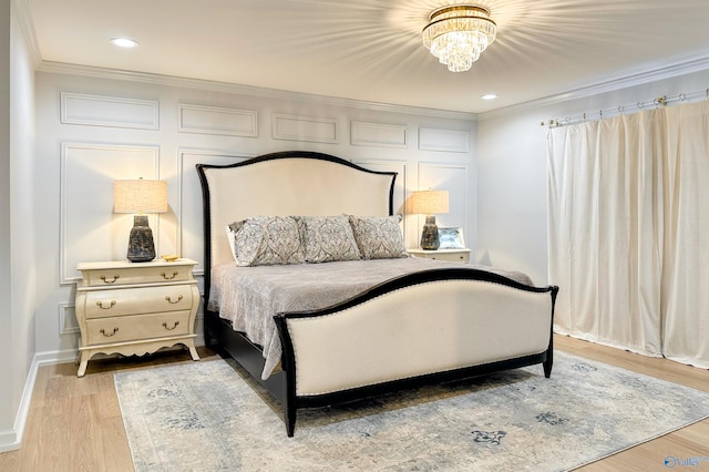bedroom featuring ornamental molding, light hardwood / wood-style floors, and a notable chandelier