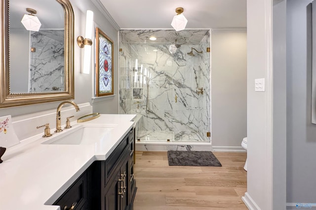 bathroom featuring hardwood / wood-style flooring, vanity, an enclosed shower, toilet, and crown molding