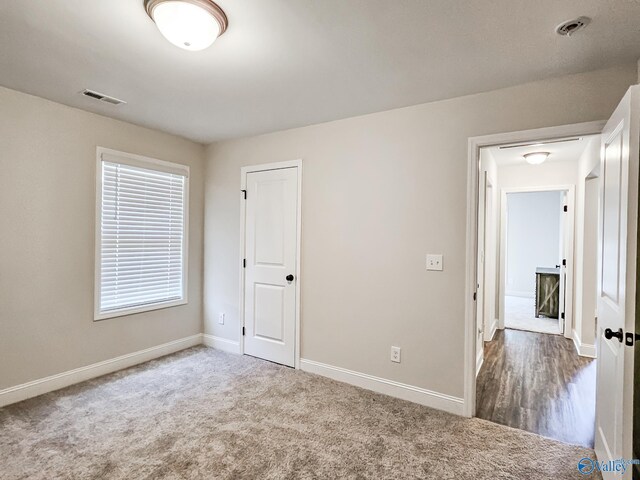 unfurnished bedroom with baseboards, visible vents, and carpet floors