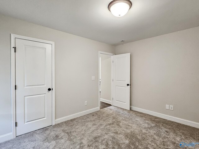 unfurnished bedroom with carpet flooring and baseboards