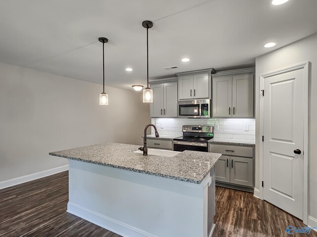 kitchen featuring dark wood-style flooring, a sink, gray cabinetry, appliances with stainless steel finishes, and tasteful backsplash