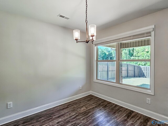 unfurnished room featuring visible vents, baseboards, an inviting chandelier, and dark wood-style flooring