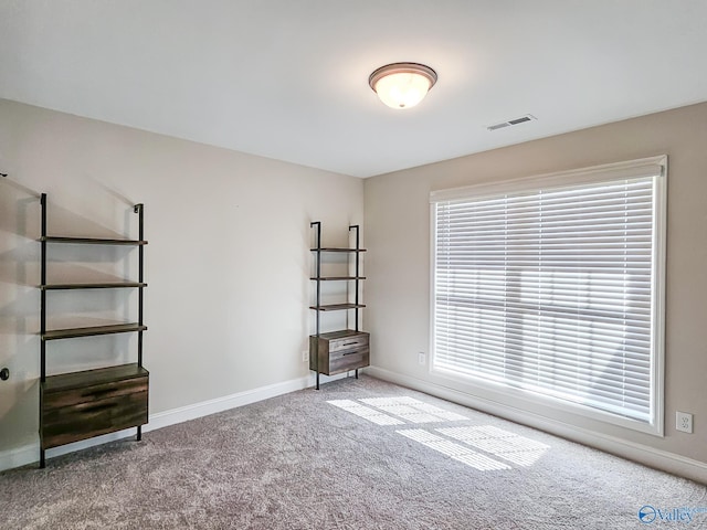 empty room with visible vents, carpet flooring, and baseboards