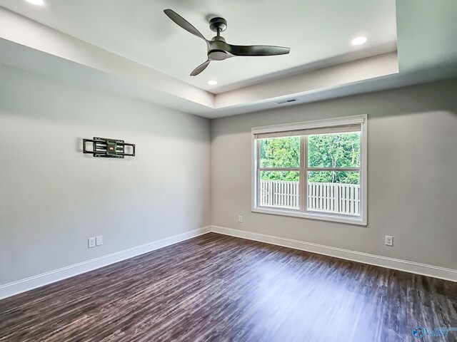 unfurnished room featuring visible vents, baseboards, ceiling fan, and dark wood-style flooring