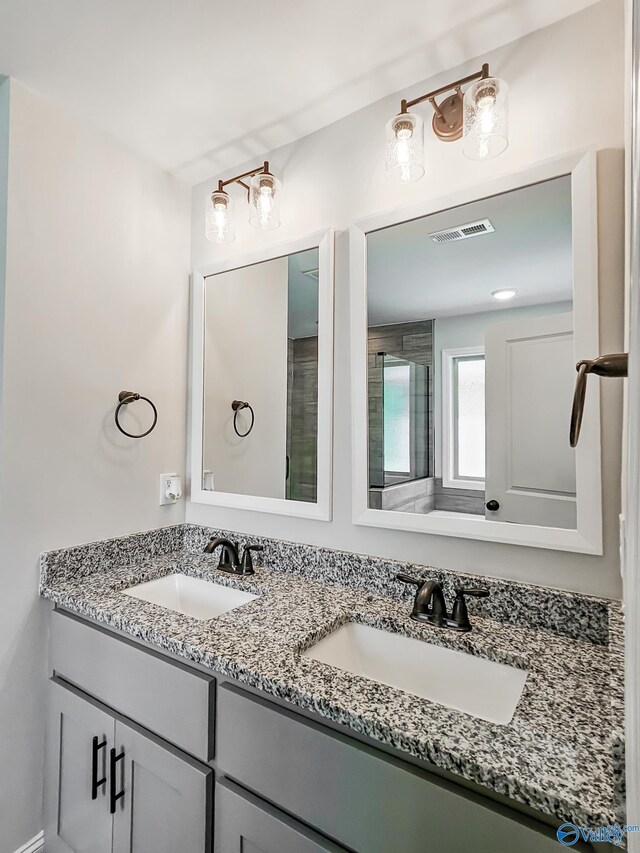 bathroom featuring double vanity, visible vents, and a sink