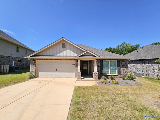 craftsman-style home featuring an attached garage, a shingled roof, a front lawn, concrete driveway, and brick siding