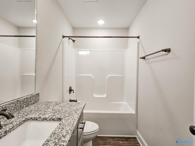 full bathroom featuring vanity, wood finished floors, baseboards, shower / bath combination, and toilet