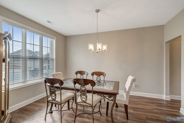 dining area featuring a notable chandelier and dark wood-type flooring