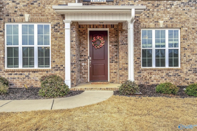 view of exterior entry featuring a lawn