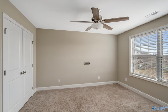 unfurnished bedroom featuring ceiling fan, a closet, and light carpet