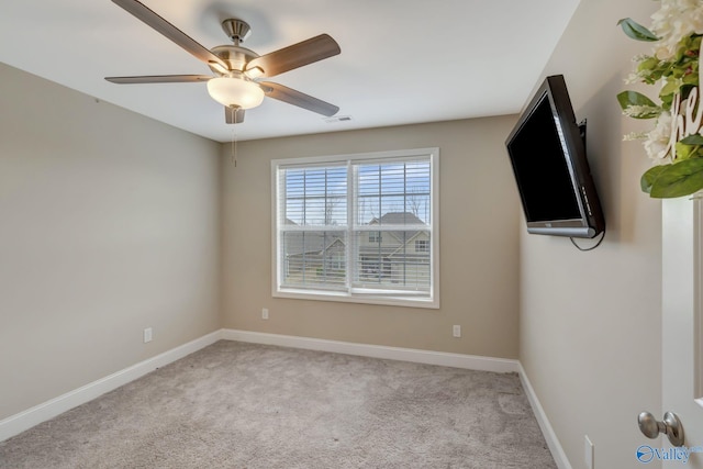 carpeted spare room with ceiling fan