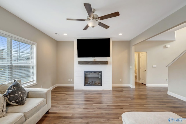 living room featuring hardwood / wood-style flooring, a fireplace, and ceiling fan