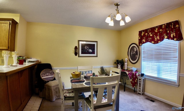 dining area featuring light colored carpet, a textured ceiling, and a notable chandelier