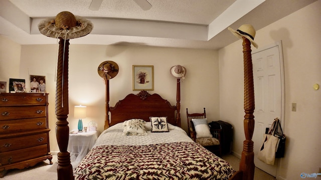 bedroom with ceiling fan, light carpet, and a textured ceiling