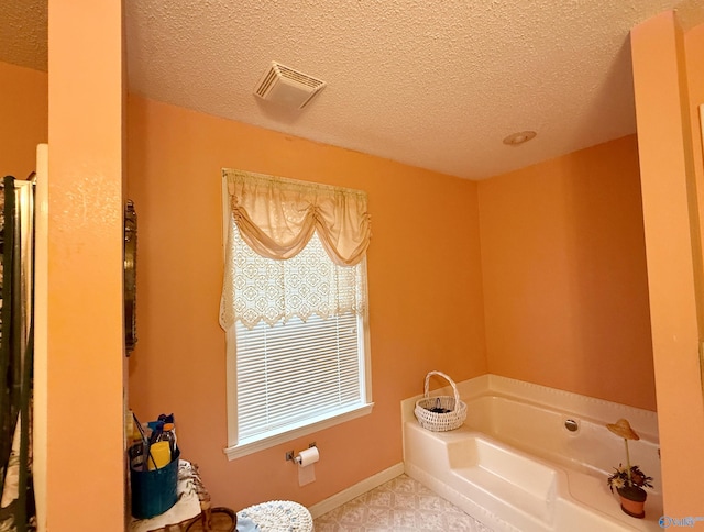 bathroom featuring a bath and a textured ceiling