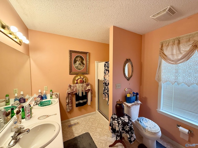 bathroom featuring plenty of natural light, toilet, and a textured ceiling