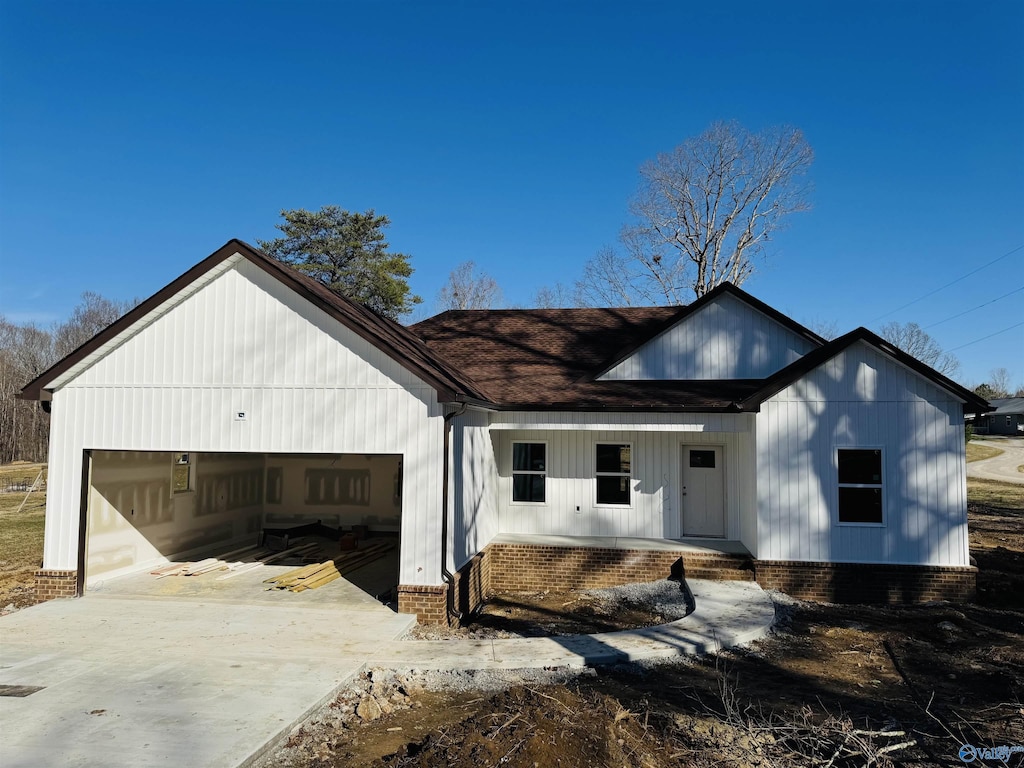 modern farmhouse style home featuring covered porch, driveway, and an attached garage