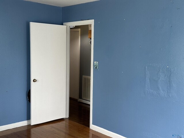 spare room with wood finished floors and baseboards