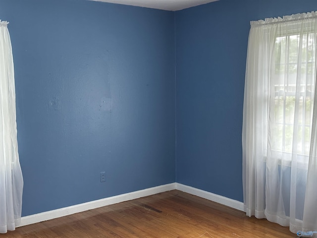 empty room featuring baseboards and wood finished floors