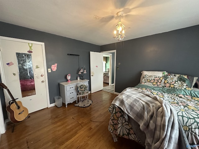 bedroom with dark wood-type flooring, a chandelier, and baseboards