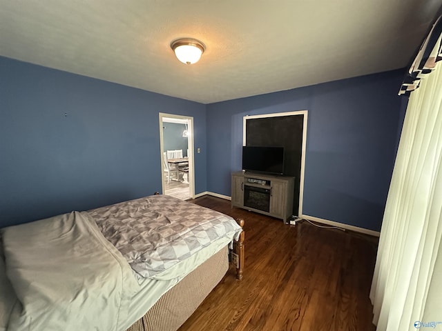 bedroom featuring wood finished floors and baseboards