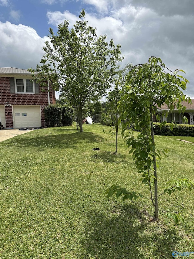 view of green lawn with a garage